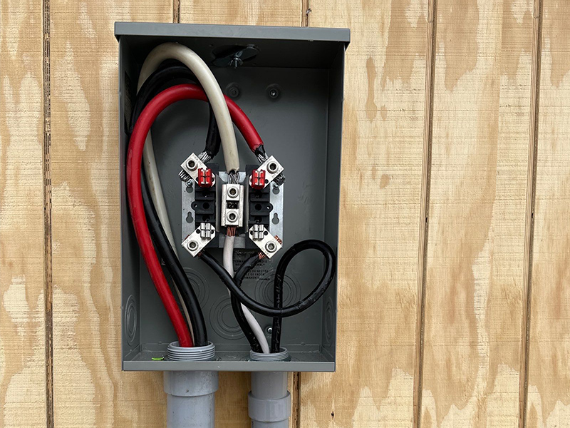 Exterior service equipment with conductors and conduit on unfinished structure wall