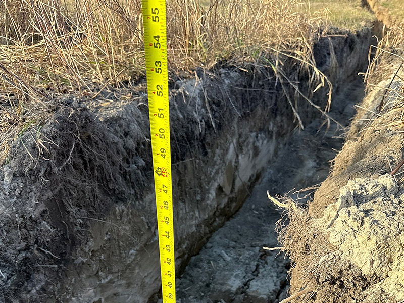 Measuring tape showing trench depth for underground service routing