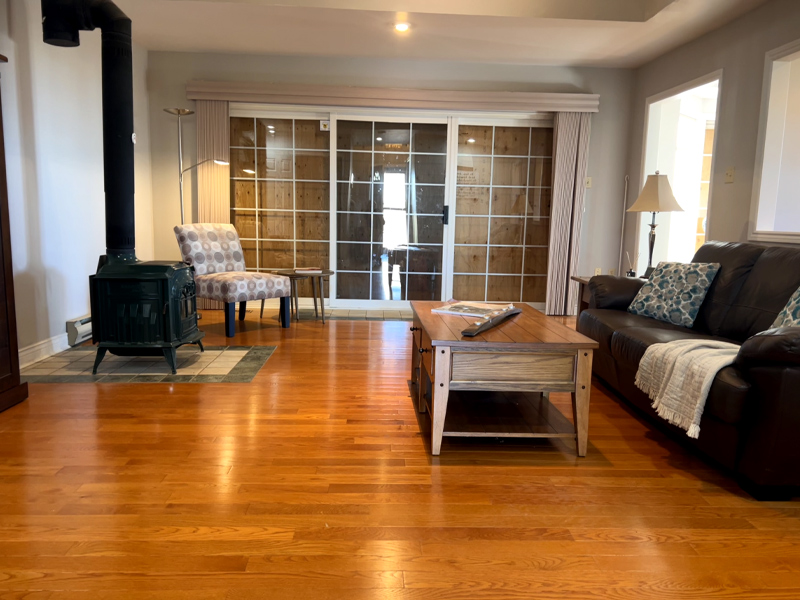 Living room after decluttering and organizing support, with the floor cleared, furniture arranged, and the space ready to use.